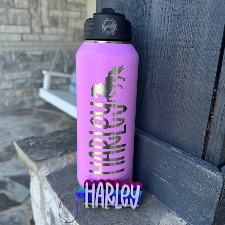 Purple water bottle with a horse design and 'Harley' text, leaning against a stone wall.