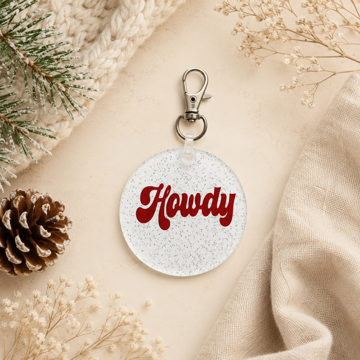 Round keychain with 'Howdy' text on a textured surface with decorative elements