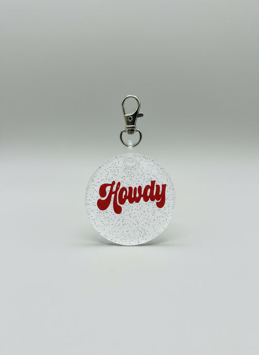 2" Round Keychain. White Glitter backer with Howdy in a dark red color