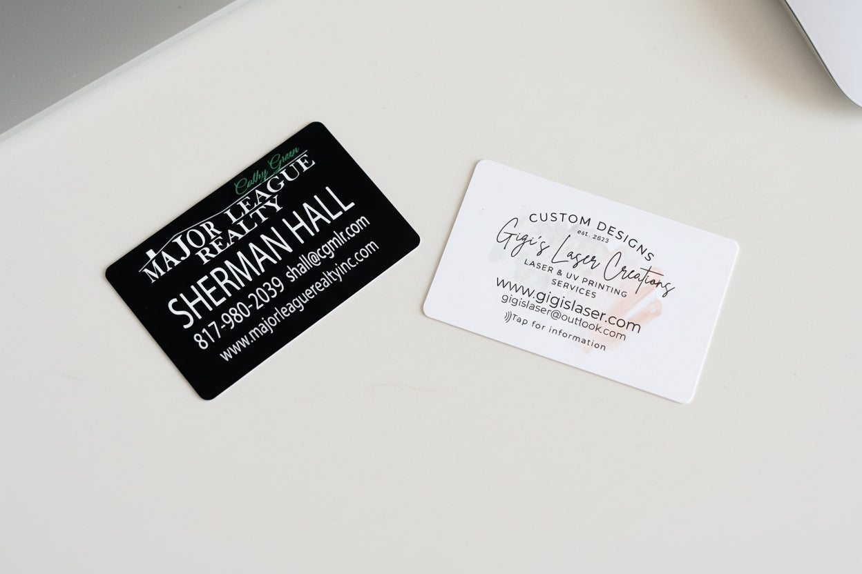Two NFC enabled business cards on a textured surface, one black and one white.