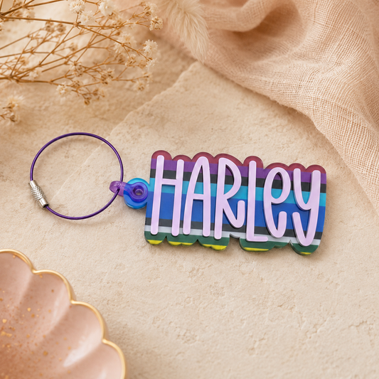 Colorful keychain with 'HARLEY' on a beige fabric background