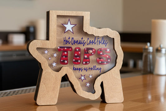Wooden tip jar shaped like a Texas with patriotic text. 